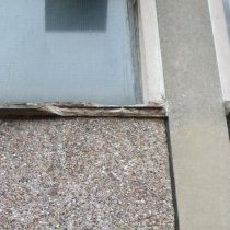 Uszkodzony parapet betonowy