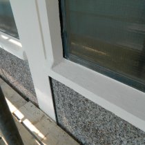 Odbudowany parapet betonowy i ściana budynku zabezpieczona z użyciem materiałów firmy Belzona