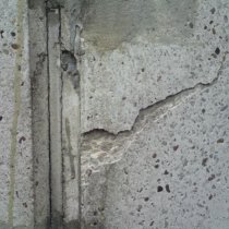 Wykruszenia powierzchni komina betonowego pod wpływem przenikania wilgoci