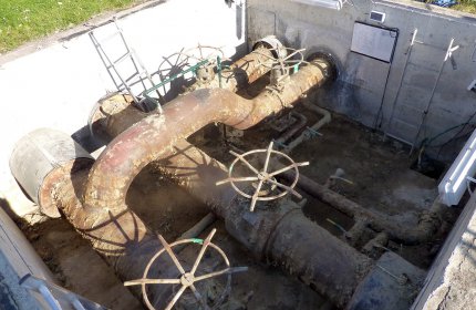 Widok ogólny skorodowanego rurociągu w komorze dostępowej zakładu ciepłowniczego